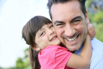 Fototapeta premium Portrait of little girl hugging her daddy