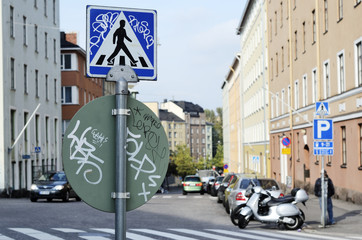 road signs with graffiti at a crossroads