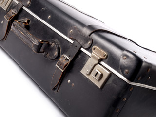An old black vintage leather suitcase with straps and locks