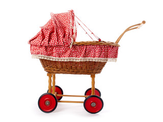 An old vintage childrens doll stroller over a white background