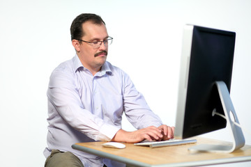Tired employee in glasses asleep while working on computer