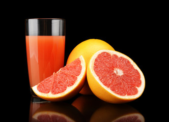 Studio shot sliced three grapefruits with juice isolated black