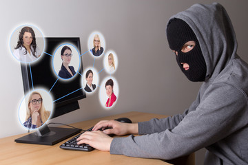 masked thief stealing data from computers