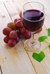 Glass filled with Red Grape Juice  and ripe sweet grape fruit on