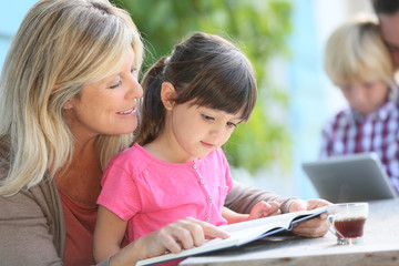 Woman with daughter teaching how to read