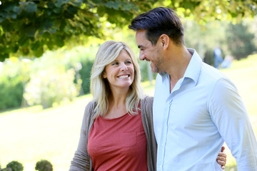 Couple walking hand in hand in park