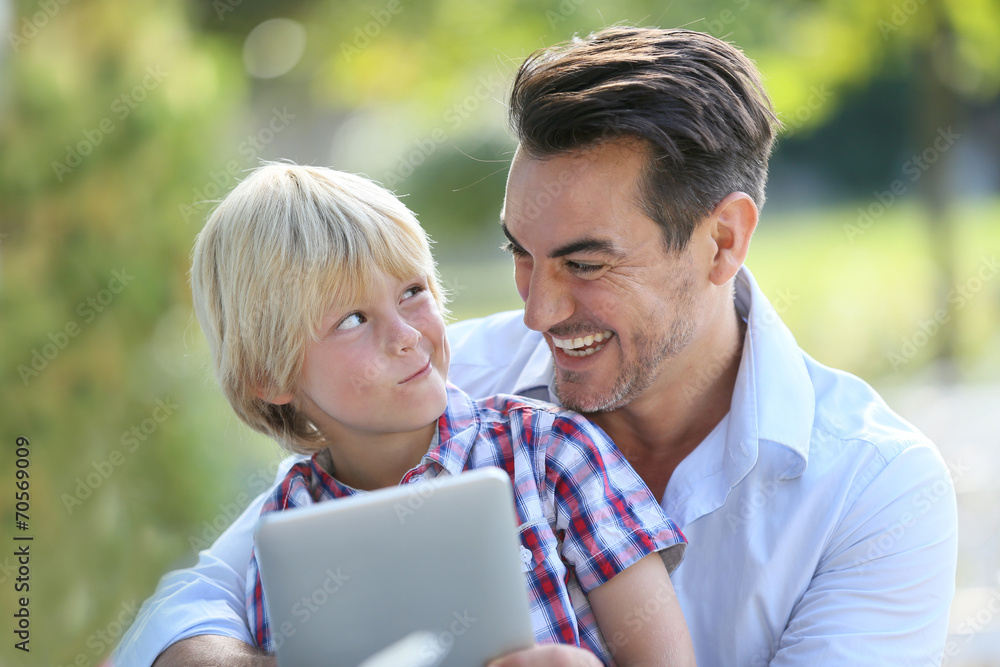 Wall mural Portrait of man with son using digital tablet