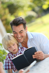 Daddy with kid reading book
