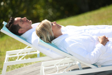 Couple relaxing by luxury hotel swimming-pool