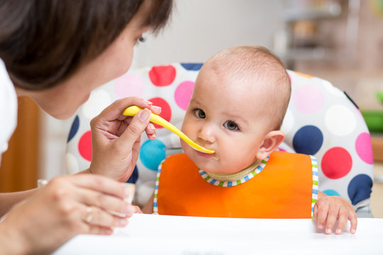 baby eating healthy food on kitchen