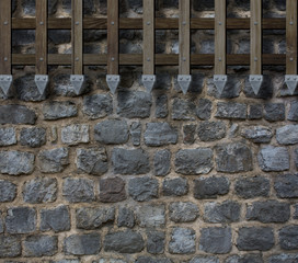 medieval old wooden gate bars on castle stone wall