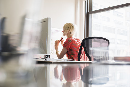 Office life. A young woman working at an office desk.