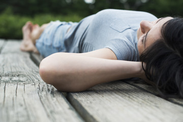 A couple relaxing on a jetty overlooking a mountain lake.