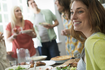 A family gathering for a meal. Adults and children around a table.