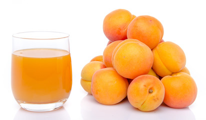 Glass of apricot juice next to a heap of apricots