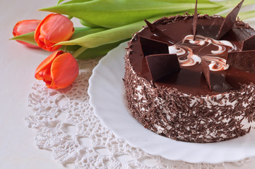 chocolate cake with tilips on the lace napkin
