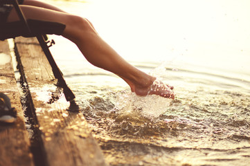 Young woman at river on evening sunset,