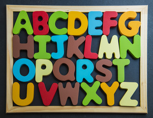 Colorful wooden alphabet on black board