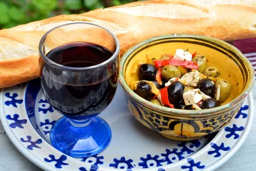 Foto auf Glas Eine Schüssel Oliven mit Baguette und Rotwein. © trinetuzun