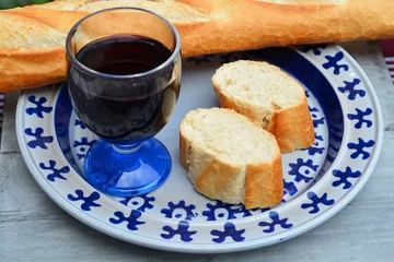 Rollo stokbrood en rode wijn op een blauw bord © trinetuzun