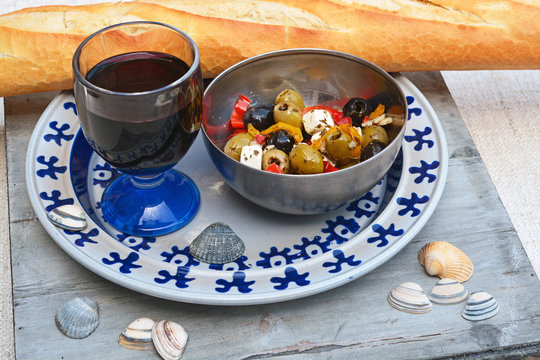 Een schaaltje olijven met stokbrood en rode wijn.