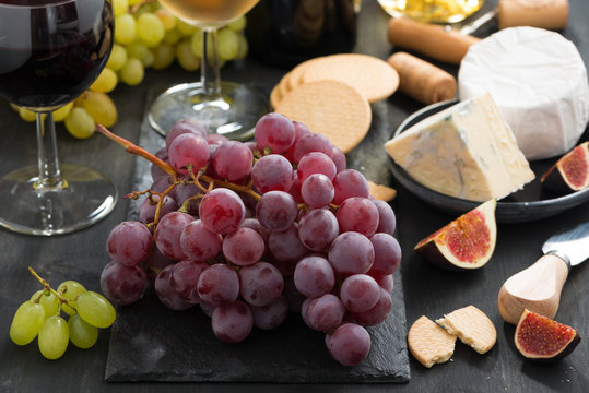 bunch of red grapes, assorted cheeses and appetizers