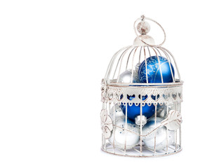 Blue and silver christmas balls in cage on the  isolated white b