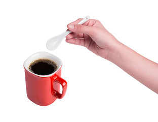 Hand holding white spoon and red cup of coffee isolated on white