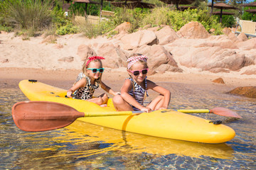 Little adorable girls enjoying kayaking in the clear turquoise