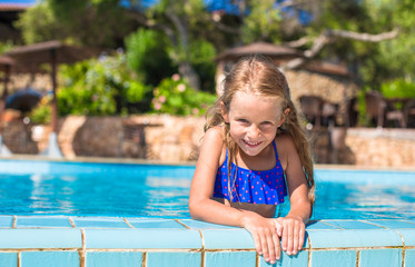 Naklejka premium Adorable happy little girl have fun in the swimming pool