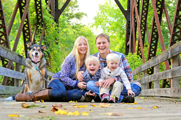 Portrait of Happy Family and Dog Outside in Fall