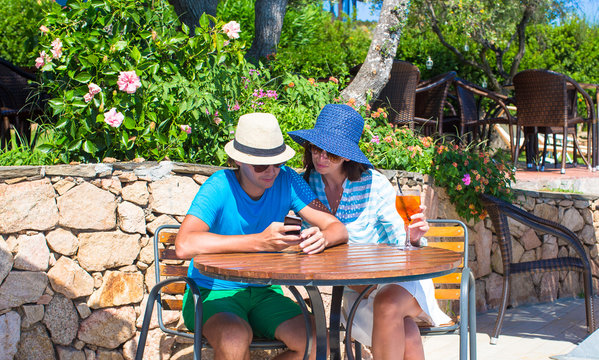 Young couple with smartphone in outdoor cafe