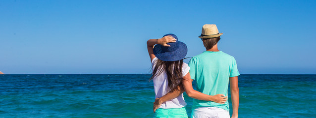 Back view of romantic couple at white beach during tropical