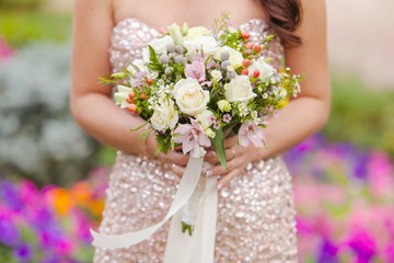 wedding bouquet of roses in the hands of the bride
