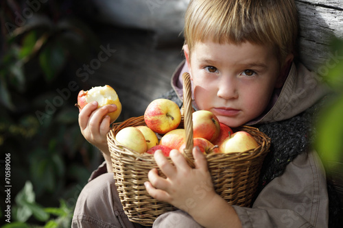 boy with a basket of apples in the hands of