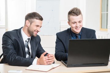 Fototapeta premium Waist-up portrait of two handsome businessmen in suits
