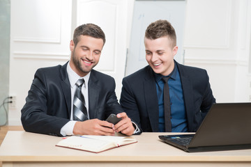 Waist-up portrait of two handsome businessmen in suits