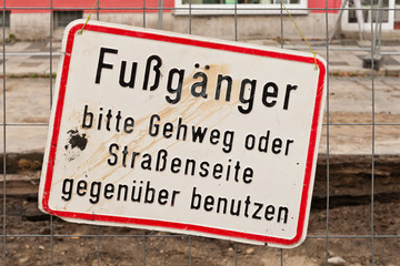 Ein schmutziges Schild an einem Bauzaun