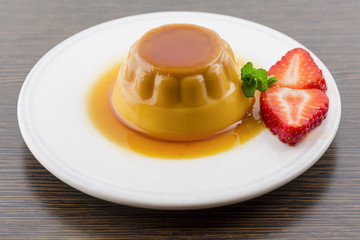 Creme caramel vanilla custard dessert or flan on white dish with