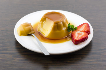 Creme caramel vanilla custard dessert or flan on white dish with