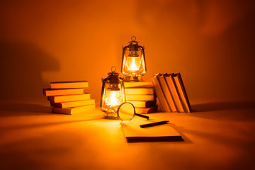 Burning kerosene lamps and books, concept magic of light