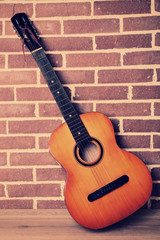 Fototapeta na wymiar Guitar on floor on brick wall background
