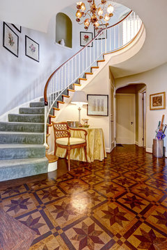 Luxury foyer with designed hardwood floor and spiral staircase