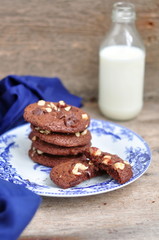 Chocolate and hazelnut cookies with milk, selective focus