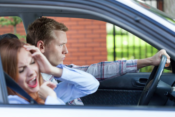 Young couple screaming in car