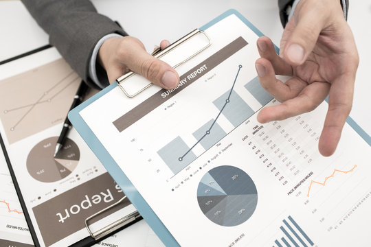 Close-up of graphs and charts analyzed by businessman