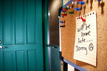 Message or reminder board with "will be home late, sorry" note