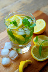 Glass with cold refreshing lemonade with fresh mint and ice