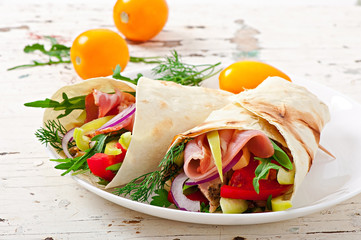 Fresh tortilla wraps with meat and vegetables on plate