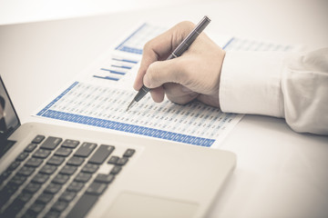 man hand with pen and business report. Accounting